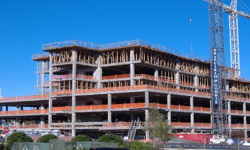 Multi-story commercial building under construction with a tower crane